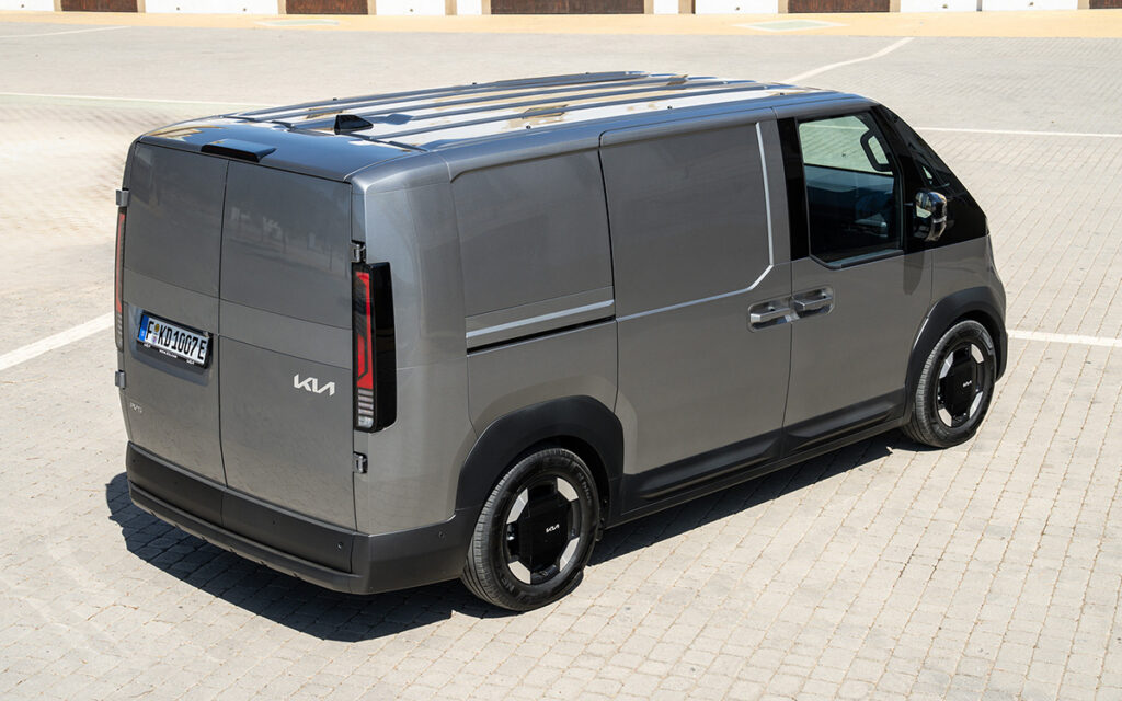 Photo of a parked KIA PV5 Cargo van, seen in angled profile from the rear.